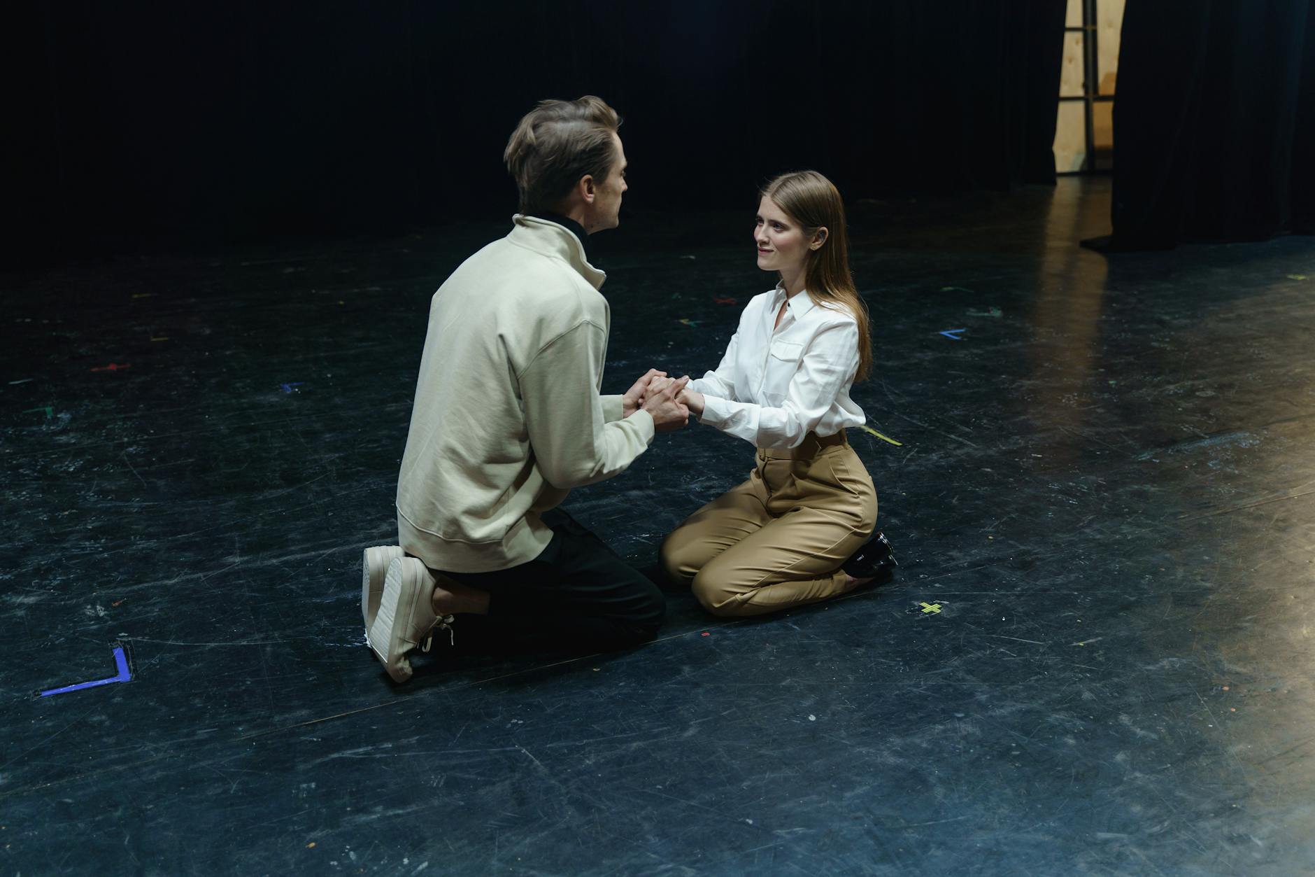 man kneeling in front of a woman sitting on floor